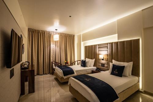a hotel room with two beds and a window at Mastiff Grand The Sia Palace Suites & Banquets, Khopoli, Near Imagica in Khopoli