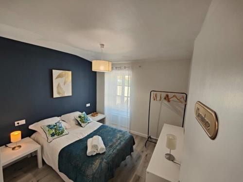 een slaapkamer met een bed en een blauwe muur bij Charmante maison de Ville , 4 personnes , LES HERBIERS in Les Herbiers