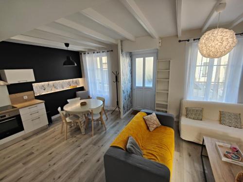 een woonkamer met een bank en een tafel bij Charmante maison de Ville , 4 personnes , LES HERBIERS in Les Herbiers