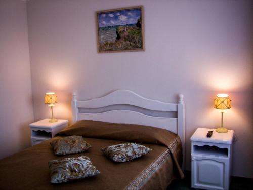 a bedroom with a bed with two lamps on both sides at Dnepropetrovsk Hotel in Dnipro