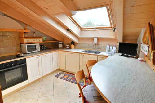 a small kitchen with a table and a window at Mansarda Le Genziane di Fiemme in Cavalese