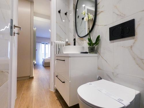 a white bathroom with a toilet and a mirror at Elegant Suite - Piraeus in Piraeus