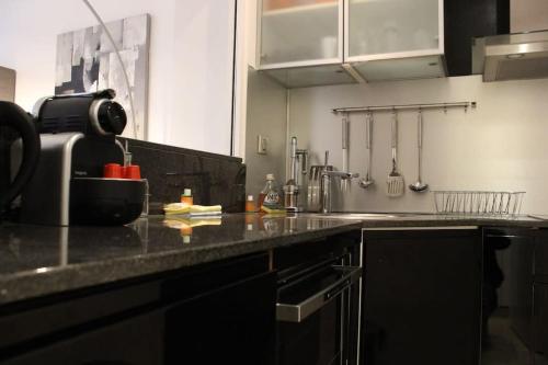 une cuisine avec un comptoir noir dans l'établissement C056-Cannes Rue Antibes - Studio, à Cannes