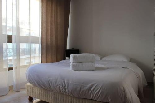 une chambre avec un lit avec des draps blancs et des oreillers dans l'établissement C056-Cannes Rue Antibes - Studio, à Cannes