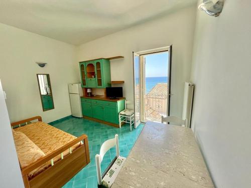 a room with a bed and a kitchen with a table at Florenza Residence in Sperlonga