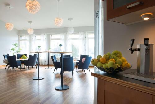 Scandic Uppsala Nord في أوبسالا: مطبخ مع طاولة وكراسي ووعاء من الفواكه