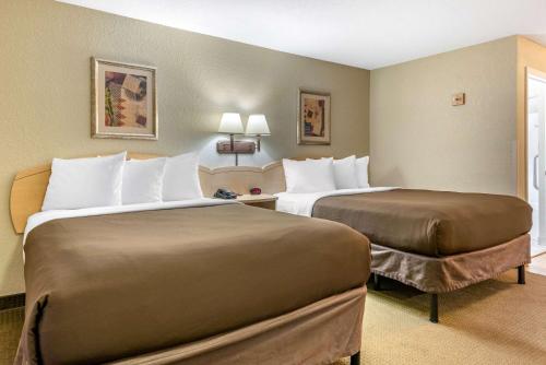 a hotel room with two beds in a room at Suburban Studios South Bend in South Bend