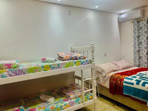 two bunk beds in a small room with a bed at Pousada cantinho do Descanso in Penha