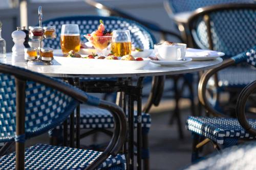 a table with a plate of food and glasses of beer at The Relais Cooden Beach and Spa in Bexhill