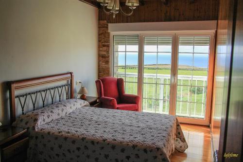 Un dormitorio con una cama y una silla y una ventana. en La Morada del CABO PEÑAS EL FARO - Gozón - Luanco, en Ferrero