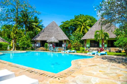einen Pool in einem Resort mit strohgedeckten Hütten in der Unterkunft Oasis Diani Beach Villas in Diani Beach