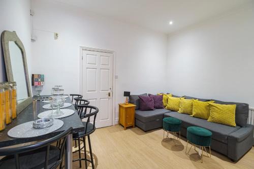 a living room with a couch and a table and chairs at Larger Groups Apartment with Garden and Parking in London