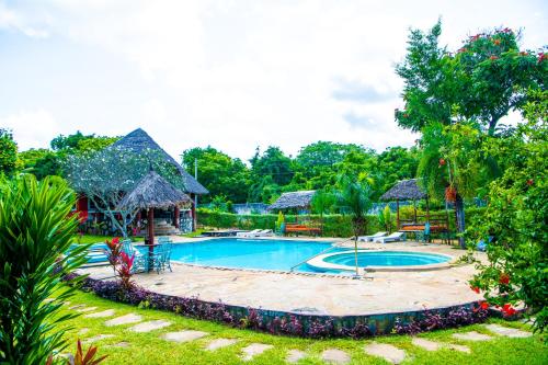 a swimming pool in a yard with a resort at Oasis Diani Beach Villas in Diani Beach