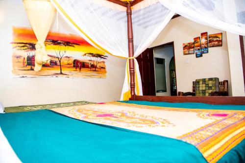 a bedroom with a bed with a canopy and a painting on the wall at Oasis Diani Beach Villas in Diani Beach