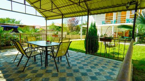 um pátio com uma mesa e cadeiras sob uma tenda em Guesthouse Vashlovani em Lagodekhi