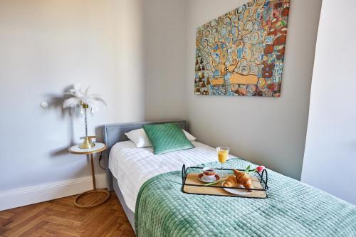 ein Schlafzimmer mit einem Bett und einem Tablett mit einer Katze darauf in der Unterkunft Art Deco Apartament dla 6 osób Chorzów/Katowice 6A in Chorzów