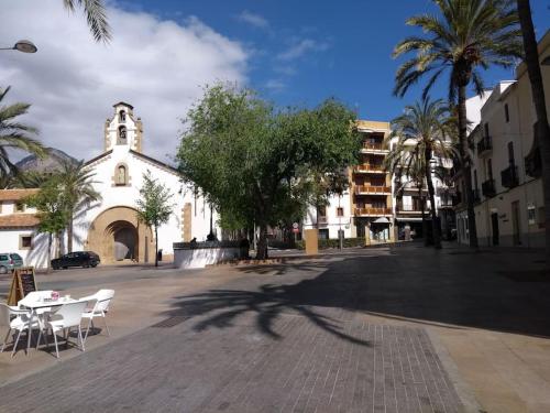 uma rua com uma igreja e uma mesa e cadeiras em Dúplex con Terraza em Xàbia
