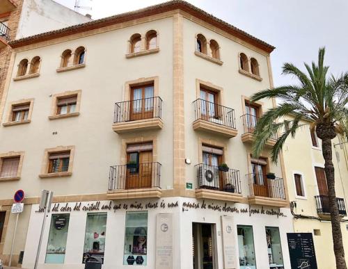 a building with a palm tree in front of it at Dúplex con Terraza in Jávea