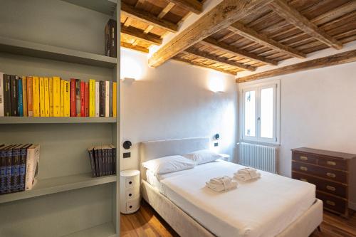 een slaapkamer met een bed en een boekenplank bij Coronari-Rental in Rome in Rome