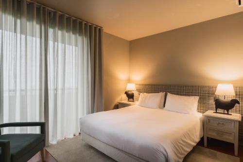 a bedroom with a large white bed and a window at The Lince Nordeste in Nordeste