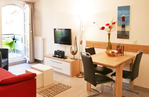 a living room with a dining room table and a television at Haus Meeresblick - Ferienwohnung Sunrise A 2.18 (Ref. 128701) in Baabe