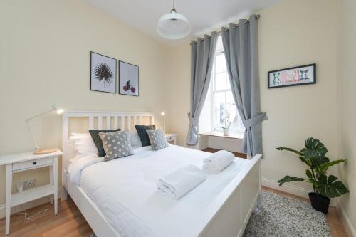- une chambre avec un lit blanc et une fenêtre dans l'établissement Bright and modern 2 bed apartment, à Édimbourg