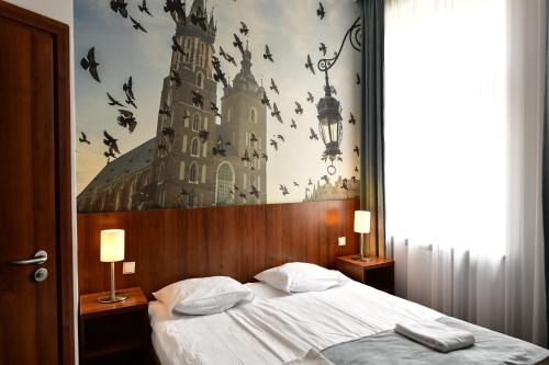 克拉科夫的住宿－Hotel Downtown Kraków，卧室配有一张大床,墙上有鸟