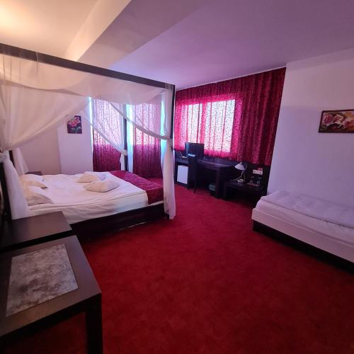 a hotel room with two beds and red carpet at Hotel Sydney in Craiova