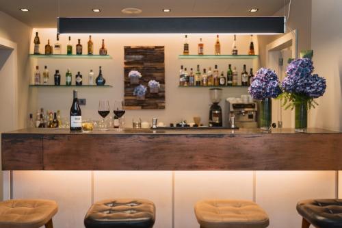 a bar with stools and bottles of wine at The Lince Nordeste in Nordeste