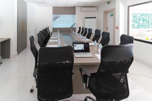 a conference room with a long table with chairs and a laptop at Ibis Styles Cayenne Centre Amazonia in Cayenne