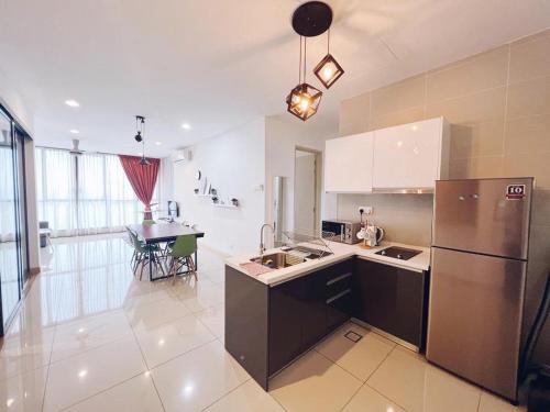 a kitchen with a stainless steel refrigerator and a table at Connected train 3 Bedrooms - ABOVE KLGATEWAY MALL 14 in Kuala Lumpur