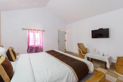 a bedroom with a bed and a tv on the wall at Marina Dessert Camp in Sām