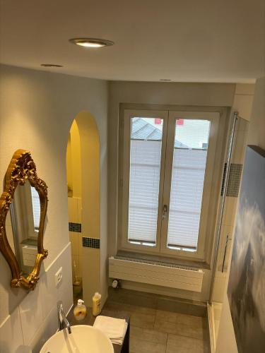 a bathroom with a window and a sink and a mirror at Interlaken Apartments in Interlaken