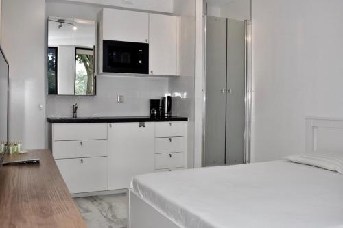 a white kitchen with a bed and a sink at 010 Studio City Center Rotterdam in Rotterdam