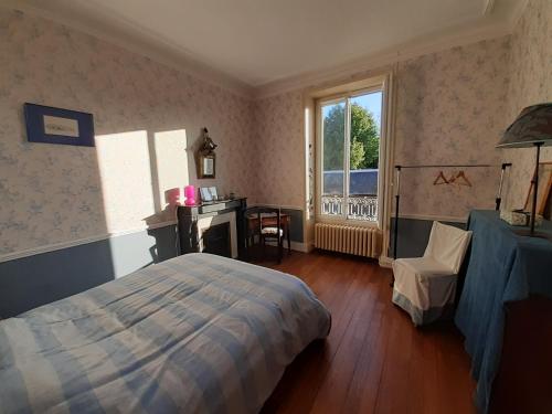 1 dormitorio con cama, escritorio y ventana en Chambres d'hôtes de Flo, en Brosses