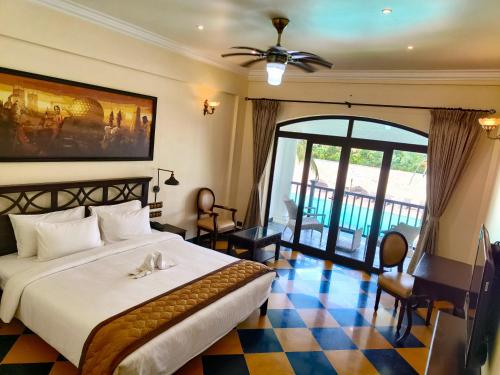 Lagoon Sarovar Premiere Resort - Pondicherry في بونديتْشيري: غرفة نوم مع سرير كبير مع أرضية مصدية