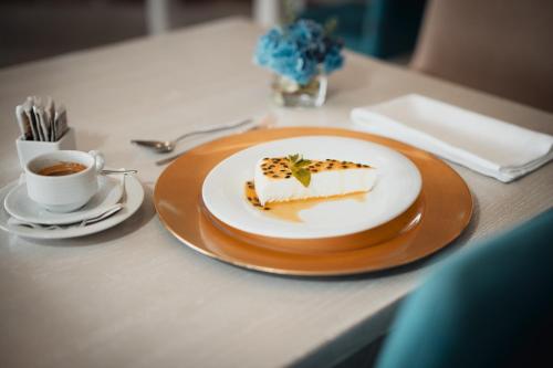 a piece of cake on a table with a cup of coffee at The Lince Nordeste in Nordeste