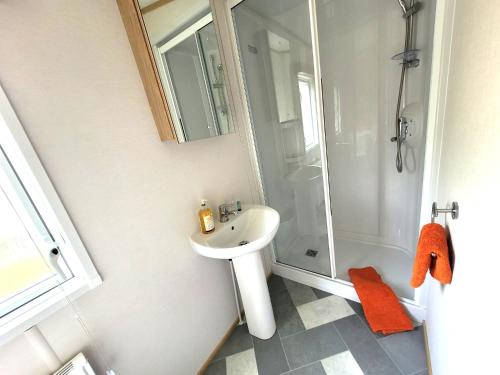 a bathroom with a sink and a shower at Primrose - 3 bedroom luxury lodge in South Cerney