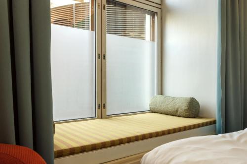 a window seat in a bedroom with a pillow at Holiday Club Tampereen Kehräämö in Tampere