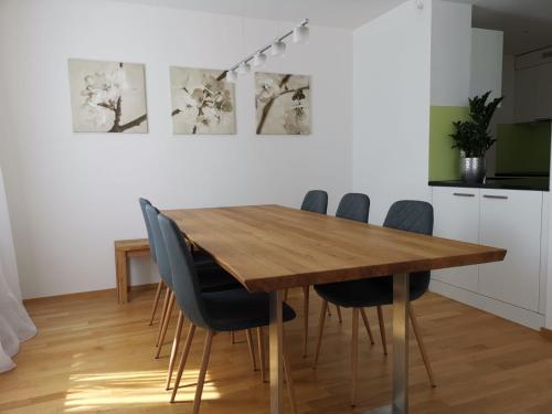 una sala da pranzo con tavolo e sedie in legno di Ferienwohnung Ladina a Disentis