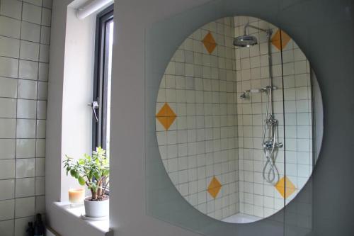 a bathroom with a mirror and a shower at Large, modern, light, open plan designer house in London