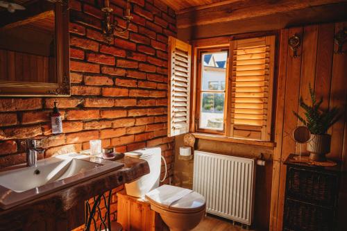 a wooden bathroom with a toilet and a sink at Skansen Bicz Resort in Stare Miasto