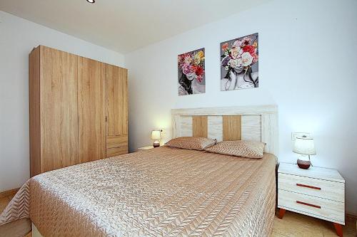 リョレート・デ・マルにあるApartment Marraのベッドルーム1室(ベッド1台付)が備わります。壁に2枚の写真が飾られています。