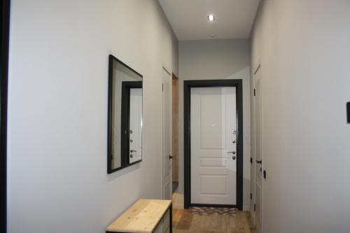 a hallway with a door and a bench and a mirror at Квартира -студия с видом на море in Aktau