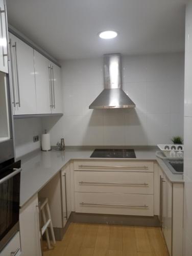 uma cozinha com armários brancos e um forno com placa de fogão em El piset de la font em Onda