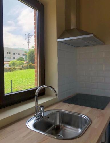 a sink in a kitchen with a window at BUNGALOW LA COCINA in Valdaliga 