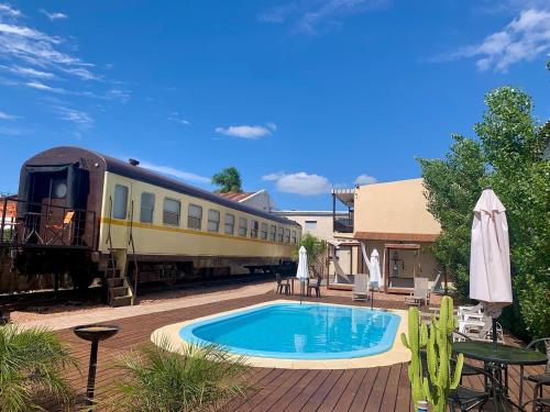un treno parcheggiato accanto a una piscina con vagone ferroviario di Hotel FK Paso de los Toros - Hotel Boutique a Paso de los Toros