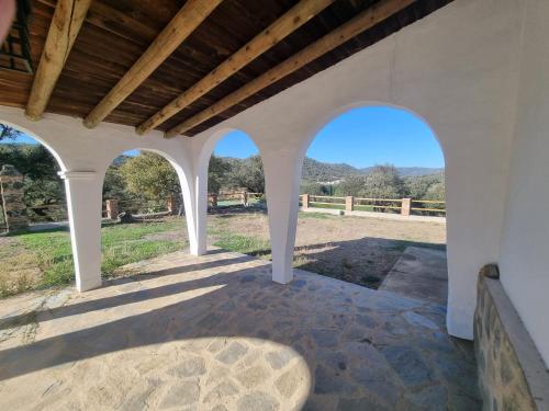 an outdoor patio with arches and a view of a field at Finca las Cabrillas La Nava in La Nava