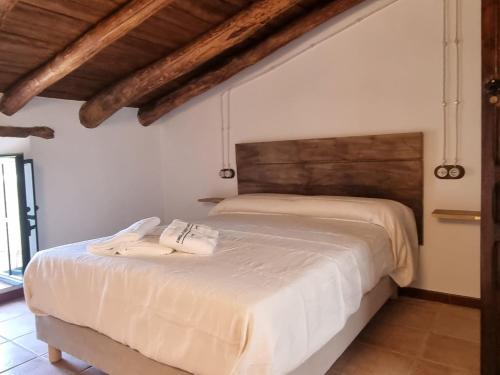 a bedroom with a large white bed with two towels on it at Finca las Cabrillas La Nava in La Nava