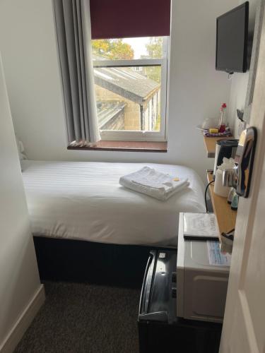 a small room with a bed and a window at Kings Hotel in Newmarket